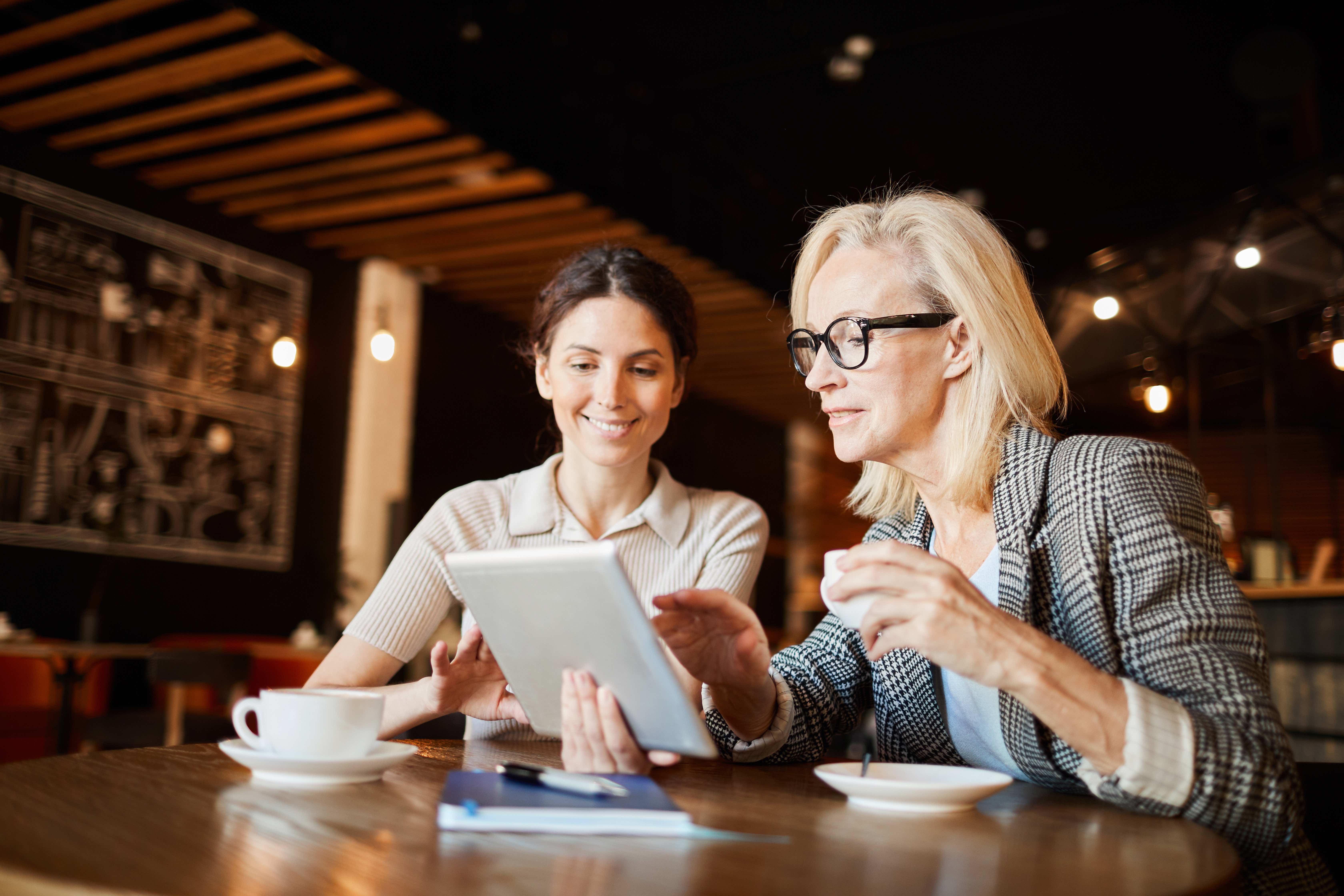 Beratungsgespräch zwischen zwei Geschäftsfrauen über AI Strategy und digitale Transformation